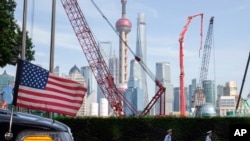 资料照:中国交警在上海一家酒店外一辆挂有美国国旗的使馆车辆旁走过。