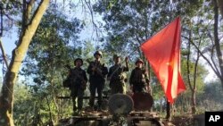Quân kháng chiến Myanmar giương lá cờ của họ trên một chiếc thiết giáp của quân đội mà họ chiếm được