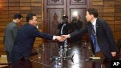 韩国首席谈判代表金基雄(右)星期四在板门店朝鲜一侧与朝鲜首席谈判代表握手。(2015年11月26日 韩国统一部提供照片)