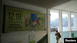 资料照片:一名行人走过香港立法会选举的广告(2021年12月1日)