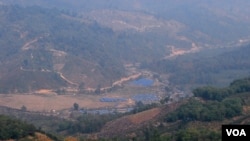 位于中缅边境大山里的克钦难民营(蓝色屋顶)。从中国境内一侧拍摄。(美国之音朱诺拍摄,2015年3月16日)