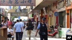 2011年8月2日,一名警察在中国新疆喀什发生袭击的现场附巡逻 (美联社资料照片)