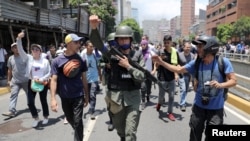 一名委内瑞拉国民警卫队成员在加拉加斯街头加入反马杜罗政府的游行,支持反对派领袖瓜伊多。(2019年4月30日)