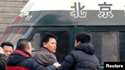1月23日赵常青的律师张雪忠(中)在法院外和便衣警察争论。张雪忠曾是华东政法大学副教授,因为思想而被解聘