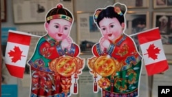 2010年2月18日,加拿大的不列颠哥伦比亚省的温哥华,在中国城一座商业大楼的入口处,有加拿大国旗和华人庆祝农历新年的招财进宝童男童女画像。
