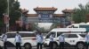中国警察在被关闭的北京新发地农产品批发市场的入口处站岗。（2020年6月13日）
