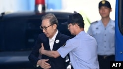 韩国前总统李文博抵达首尔一家法庭参加庭审。(2018年9月6日)
