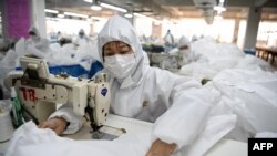在温州一家工厂,工人们正在缝制防护服。(2020年2月28日)