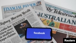 2021年2月18日,在澳大利亚的堪培拉,一个显示“Facebook”标志的手机屏幕和澳大利亚报纸的插图。
