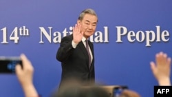 正在北京举行的中国全国人大会议星期五举行外交主题记者会,中国外交部长王毅在离开记者会时挥手致意。(2025年3月7日)