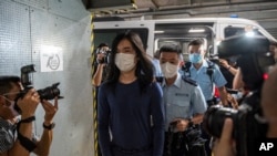 资料照:2022年7月14日,香港区域法院,警察护送曾志健走下警车。2023年10月18日星期三,在 2019 年民主抗议活动中遭警察枪击受伤的香港男子被判处47个月监禁,罪名是暴乱、袭警和妨碍司法公正。 曾志健是长达数月的抗议活动中第一位已知的警察枪击受害者。