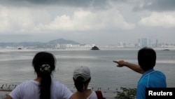 台湾金门烈屿岛上的游客用手指向中国厦门。(2018年8月20日)