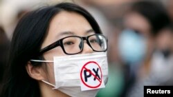 2012年10月27日,一位女士戴着对PX说不的口罩参加示威,示威者反对浙江宁波扩建石化工厂计划。