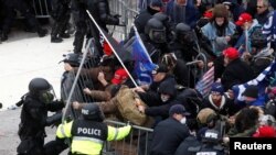 特朗普的支持者在抗议国会认证2020年总统大选结果的集会上推倒隔离栏,与国会警察爆发冲突。(2021年1月6日,)