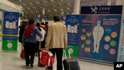 资料照片:2020年1月3日,旅客通过北京首都国际机场的健康检查关口。(美联社照片)