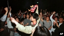 1999年5月8日,在中国驻南斯拉夫大使馆被北约轰炸之后,北京的学生在美国驻华使馆外面焚烧美国国旗。
