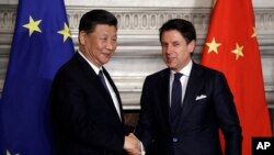2019年3月23日,中国国家主席习近平(左)与意大利前总理孔特在签署“一带一路”倡议的备忘录后握手。