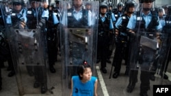 2019年6月12日,香港立法会外,一名抗议者坐在防暴警察面前。