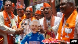 印度总理纳伦德拉·莫迪(Narendra Modi)的支持者祝贺他在印度大选初步计票中明显胜出。(法新社)