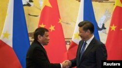 2016年10月20日,菲律宾总统杜特尔特(左)与中国主席习近平在北京举行的一场签字仪式后握手。