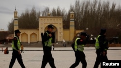在中国新疆喀什艾提尕尔清真寺前走过一队巡逻的警察。 (资料照片)