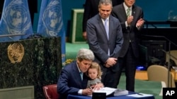 美国国务卿克里手臂中搂着他的孙女在联合国总部签署巴黎气候协议。(2016年4月22日)