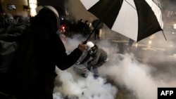 在明尼苏达州布鲁克林中心警察局外,人们躲避警方向抗议人群释放的催泪瓦斯。当地警察开枪打死一名黑人男子,引发了抗议。(2021年4月12日)