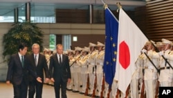 欧洲理事会主席图斯克(右)、欧盟委员会主席容克(中)在日本首相安倍晋三陪同下在日本首相府会晤前检阅仪仗队。(2015年5月29日)