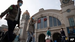 2020年4月7日武汉恢复交通前夕,带着行李的旅客走过汉口火车站。