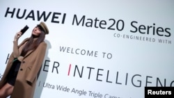 一名模特站在华为在英国伦敦发起的华为Mate20系列的广告牌前。(2018年10月16日)