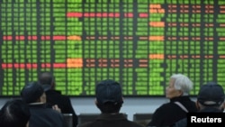 春节后中国股市开市头一天出现了崩溃式下滑。图为浙江省杭州市的股民坐在一交易所的电子屏幕前观看行情。(2020年2月3日)