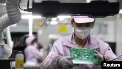 资料照片:一名女工在中国武汉的一家格力工厂的生产线上。(2021年8月16日)