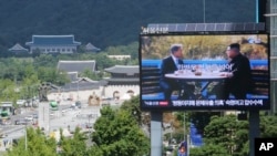 电视屏幕上显示韩国总统文在寅和朝鲜领导人金正恩的照片,标题为: 朝鲜半岛和平。