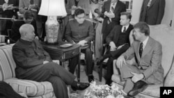 1977年2月8日,美国总统卡特及其国家安全顾问布热津斯基在白宫总统办公室会见中国驻美国联络处主任黄镇(前排左一)