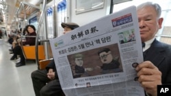 一名乘客在韩国首尔地铁中阅读朝鲜日报,该报头条报道计划中的美国总统川普与朝鲜领导人金正恩的首脑会谈。(2018年3月10日)
